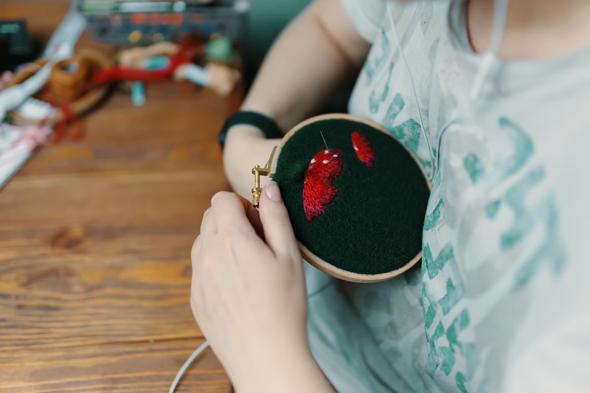 Master embroiderer stitching a detailed floral patch